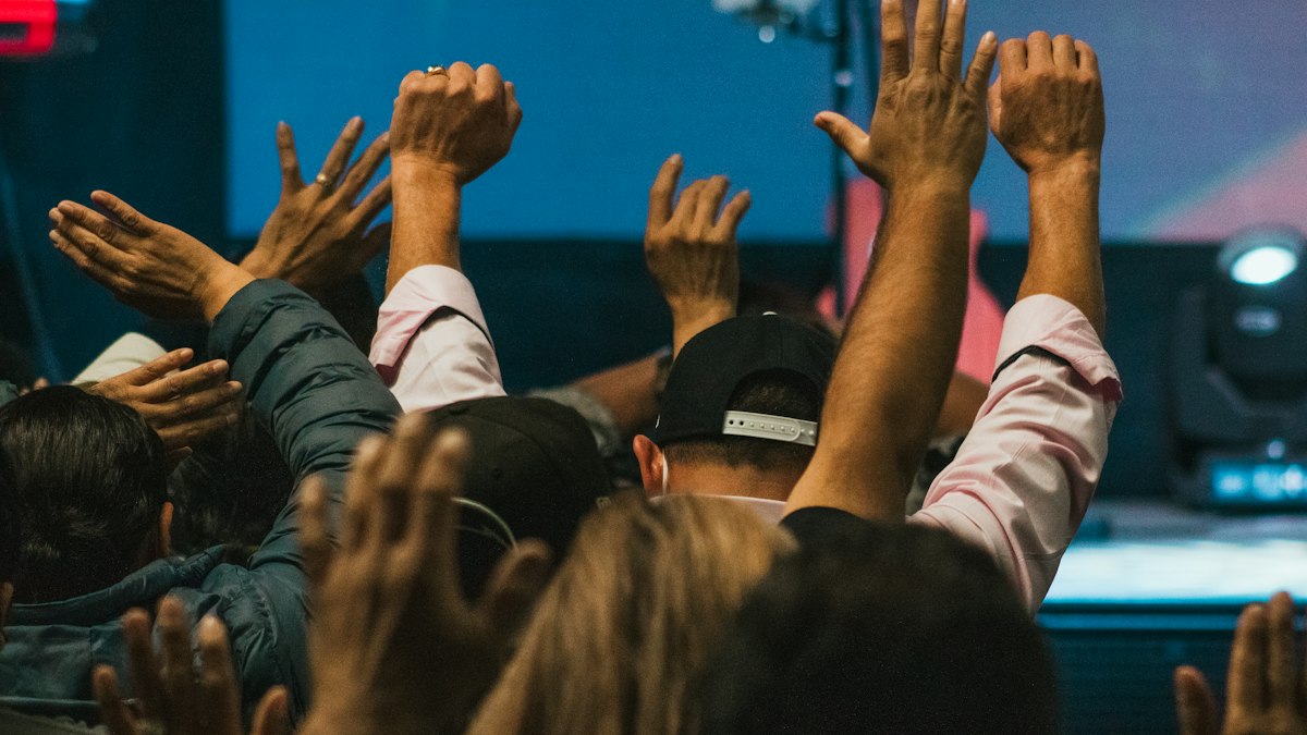 A crowd of people raising their hands in the air
