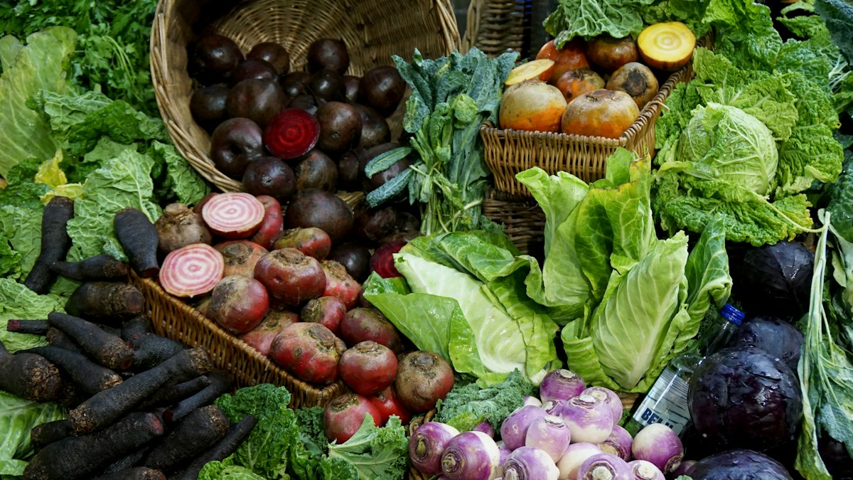 Woven baskets overflowing with fresh vegetables at a market stall